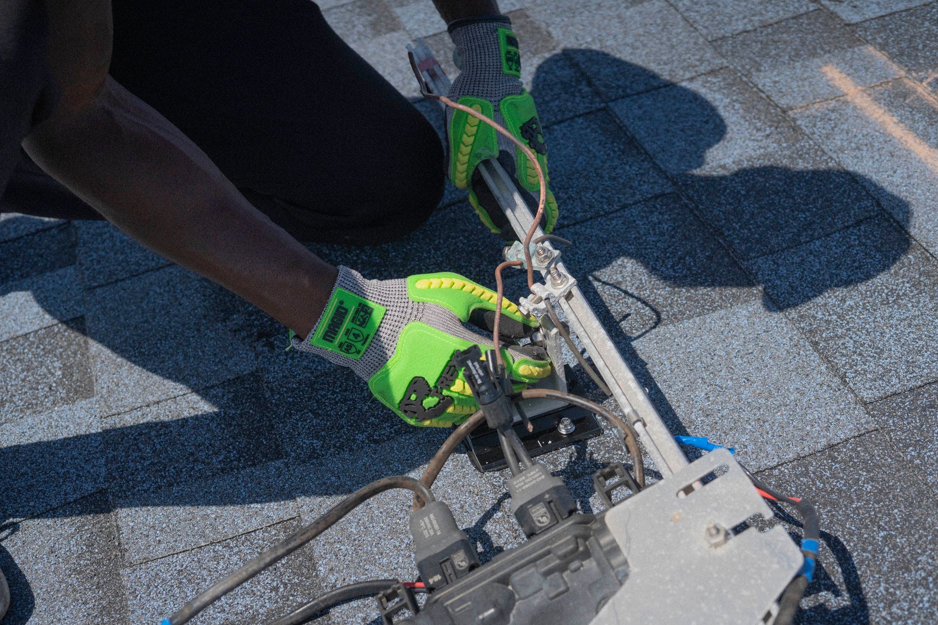 A Santa Ana Roofing team member on a ladder performing a detailed roof inspection on a residential building in a Somerville neighborhood, ensuring safety and precision.