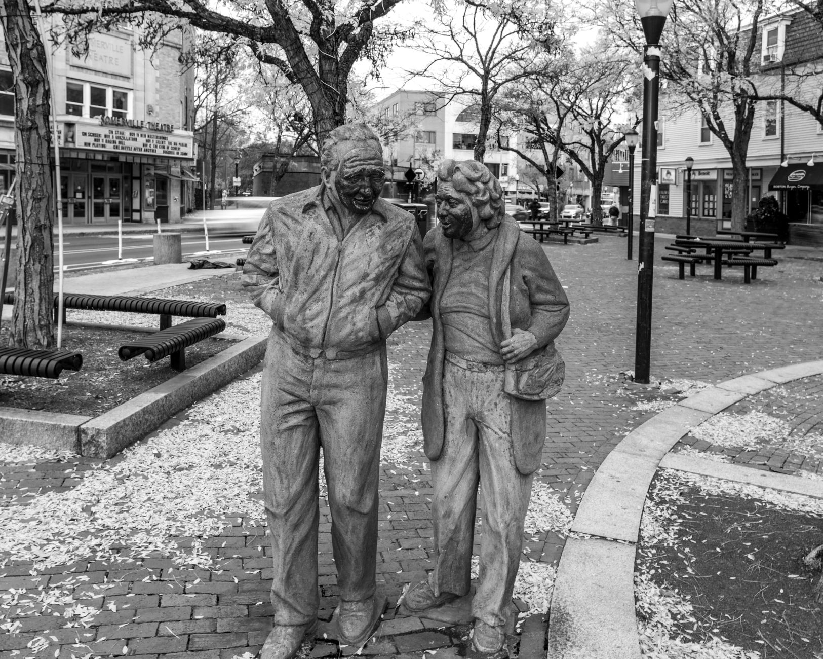Historic brick buildings and tree-lined streets in Somerville's Davis Square, bustling with pedestrians and local businesses, reflecting the city's vibrant character.