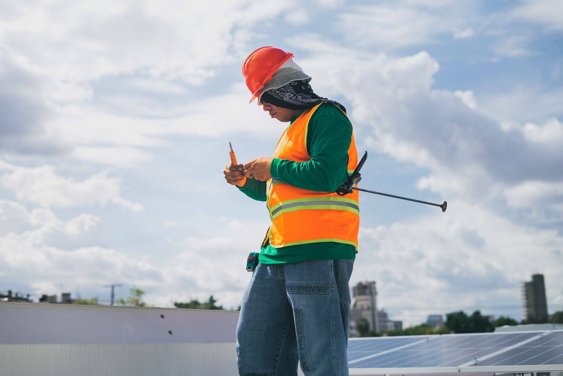 A professional roofer in Malden, Massachusetts, performing a detailed inspection of a residential roof, pointing out an area of concern to a homeowner.